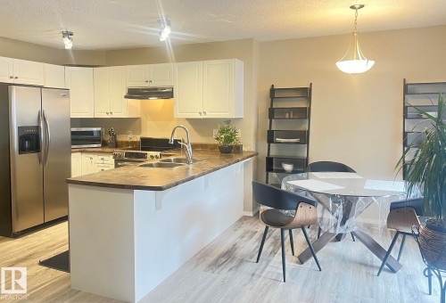 Kitchen and dining area featuring light wood-finish flooring - 5001 62 Street, Beaumont, AB 