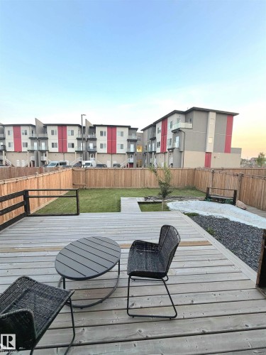Expansive wooden deck with a manicured lawn, gravel area, and a privacy fence - 20827 130 Avenue Nw, Edmonton, AB 