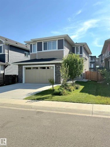 Two-story residence featuring a two-car garage, concrete driveway, and stone facade accents - 20827 130 Avenue Nw, Edmonton, AB 