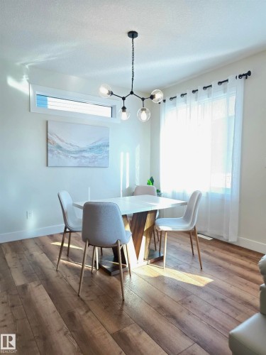 Wood-finish flooring, contemporary chandelier, transom window, and sheer window coverings - 20827 130 Avenue Nw, Edmonton, AB 