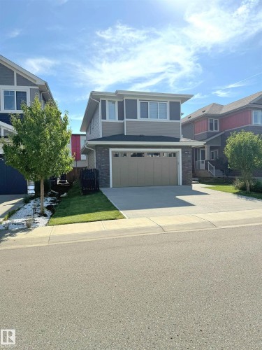 Two-story residence featuring a two-car garage, concrete driveway, stone facade accents, and a contemporary exterior - 20827 130 Avenue Nw, Edmonton, AB 