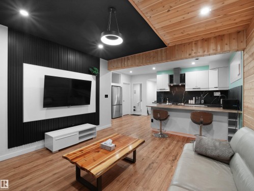 Wood-finish flooring throughout, featuring a kitchen with a breakfast bar - 20827 130 Avenue Nw, Edmonton, AB 