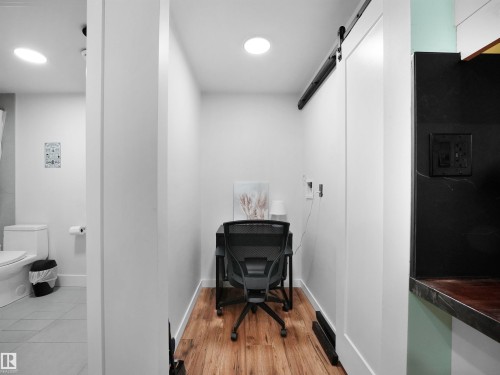 Dedicated work area featuring wood-finish flooring, recessed lighting, and a modern barn door - 20827 130 Avenue Nw, Edmonton, AB 