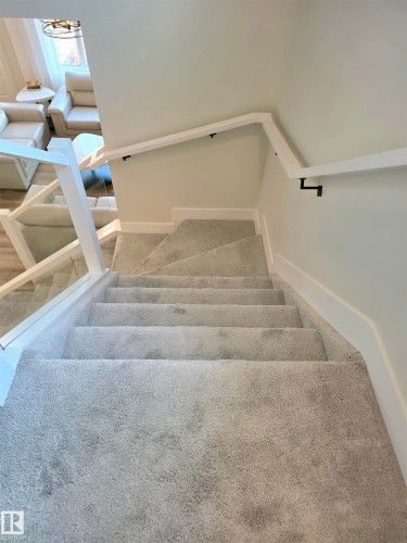 Staircase with light gray carpet and white wall-mounted handrail - 20827 130 Avenue Nw, Edmonton, AB 