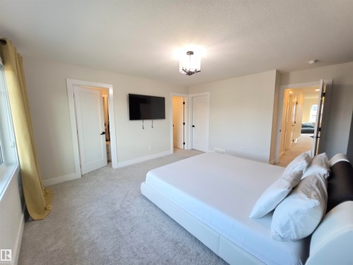 Neutral wall color, wall-to-wall carpeting, recessed lighting, and a contemporary ceiling fixture - 20827 130 Avenue Nw, Edmonton, AB 