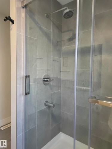 Glass-enclosed shower with a rainfall showerhead and polished chrome fixtures - 20827 130 Avenue Nw, Edmonton, AB 