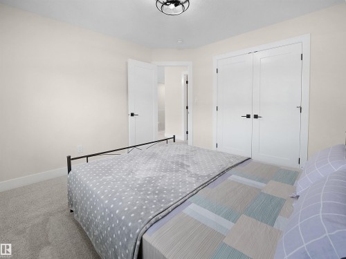 Neutral wall color, carpeted flooring, modern matte black ceiling light, white paneled doors, and matte black hardware - 20827 130 Avenue Nw, Edmonton, AB 