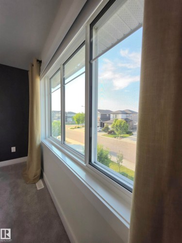Expansive window with white trim, gray carpeting, and dark accent wall - 20827 130 Avenue Nw, Edmonton, AB 