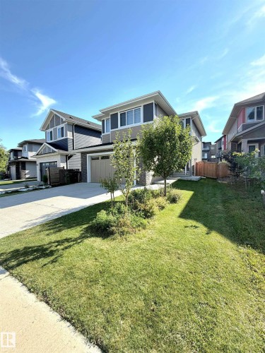 Contemporary exterior with a two-car garage, concrete driveway, and mature landscaping - 20827 130 Avenue Nw, Edmonton, AB 