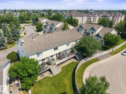 Townhome exterior featuring a pitched shingle roof, light-colored siding, and multiple balconies - 