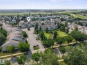 Aerial perspective of a residential complex with multiple multi-story buildings, featuring light-colored exteriors and dark-toned roofs - #15 11717 9B Av Nw, Edmonton, AB  - Outdoor With View 