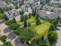 Expansive green space featuring two putting greens, mature trees, and landscaping elements - #15 11717 9B Av Nw, Edmonton, AB  - Outdoor With View 