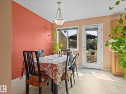 Dining area with a single-pane window and a glass-paneled door opening to an outdoor patio - 