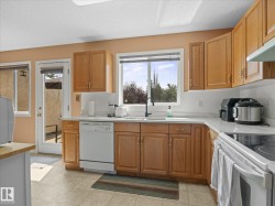 Kitchen featuring wood cabinetry, solid surface countertops, white tile backsplash, and a ceramic tile floor - 