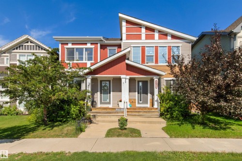 Contemporary two-story duplex with symmetrical facades, individual covered front porches, and a combination of horizontal siding and vertical paneling - 4306 Prowse Link Link Sw, Edmonton, AB 