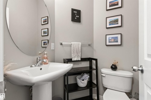 Pedestal sink with chrome faucet, oval wall mirror, and neutral wall paint - 4306 Prowse Link Link Sw, Edmonton, AB 