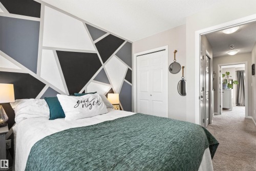 Neutral-toned walls with a geometric accent wall featuring black, grey, and white segments - 4306 Prowse Link Link Sw, Edmonton, AB 
