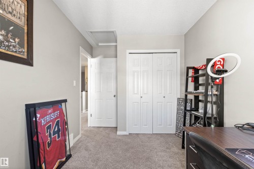 Plush carpeting throughout, neutral wall paint, white trim, and a bi-fold closet door - 4306 Prowse Link Link Sw, Edmonton, AB 