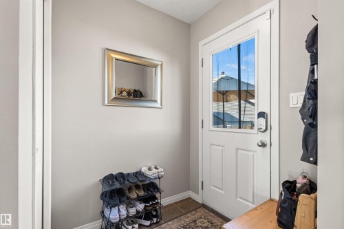White paneled exterior door with integrated window and smart lock - 4306 Prowse Link Link Sw, Edmonton, AB 