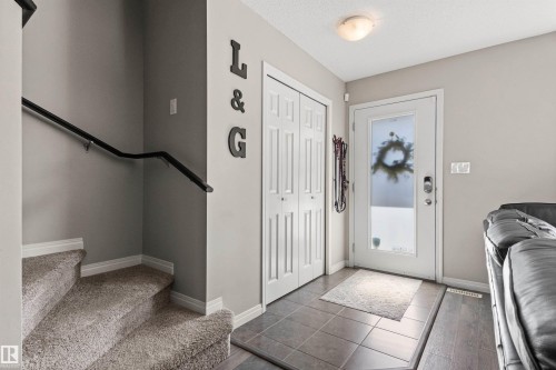 Front entry with a white door, frosted glass panel, and a smart lock - 4306 Prowse Link Link Sw, Edmonton, AB 