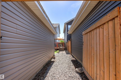 Gravel pathway with a wood-finish fence and neutral-toned siding - 4306 Prowse Link Link Sw, Edmonton, AB 
