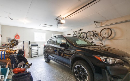 Attached garage with an overhead automatic door opener, light-colored walls, and a window - 4306 Prowse Link Link Sw, Edmonton, AB 