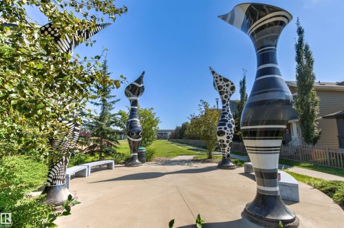 Outdoor common area featuring abstract art installations, concrete pathways, and integrated seating - 4306 Prowse Link Link Sw, Edmonton, AB 