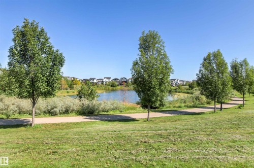 Paved pathway bordering a body of water, lined with mature trees and green space - 4306 Prowse Link Link Sw, Edmonton, AB 