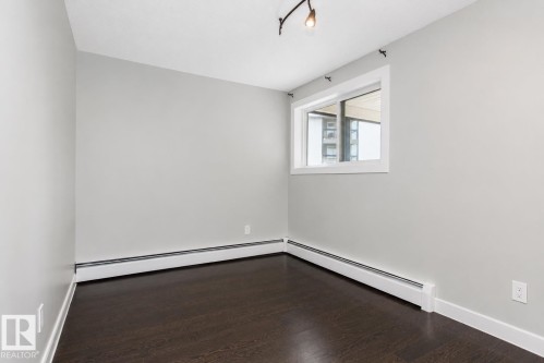 Neutral wall color complemented by dark wood-finish flooring - #203 2624 Mill Woods Rd E Nw, Edmonton, AB 