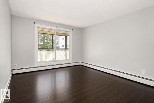 Wood-finish flooring, light grey walls, and a large sliding glass door - #203 2624 Mill Woods Rd E Nw, Edmonton, AB 