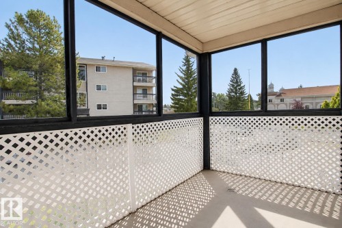 Enclosed balcony with white lattice railing and expansive windows - #203 2624 Mill Woods Rd E Nw, Edmonton, AB 