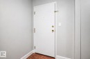 White entry door with brass hardware and tile flooring - #203 2624 Mill Woods Rd E Nw, Edmonton, AB 