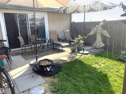 Paved patio area, sliding glass door, privacy fencing, and a grass section - 