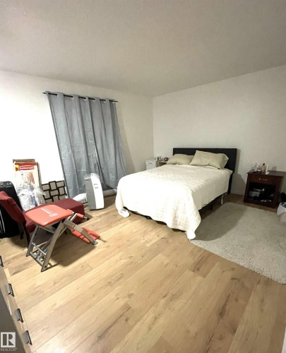 Light wood-finish flooring complements neutral wall tones - #D1 1 Garden Grove Nw, Edmonton, AB 