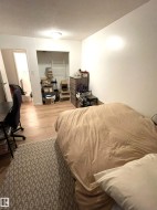Wood-finish flooring throughout, with a recessed open closet providing storage - 