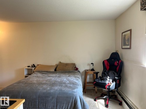 Carpeted flooring, neutral wall tones, and a single light fixture - #112 4404 122 St Nw, Edmonton, AB 