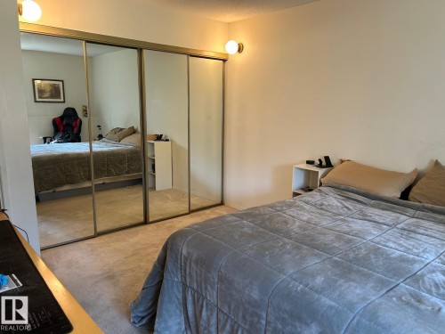 Wall-to-wall carpeting with mirrored closet doors and built-in wall sconces - #112 4404 122 St Nw, Edmonton, AB 