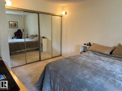 Wall-to-wall carpeting with mirrored closet doors and built-in wall sconces - 