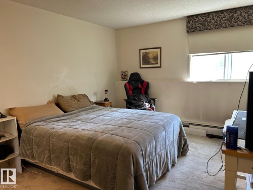 Wall-to-wall carpeting with light-colored walls and a window with a valance - #112 4404 122 St Nw, Edmonton, AB 