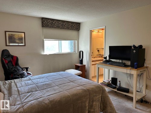 Window with roller shade and decorative valance, neutral wall paint, and carpet flooring - #112 4404 122 St Nw, Edmonton, AB 