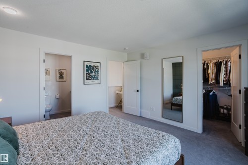 Carpeted bedroom with a full bathroom, walk-in closet, and recessed lighting - 7017 52 Avenue, Beaumont, AB 