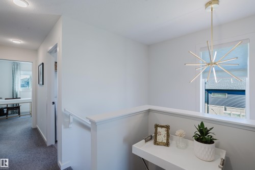 Hallway featuring recessed lighting, carpeted flooring, and a modern sputnik-style pendant light - 7017 52 Avenue, Beaumont, AB 