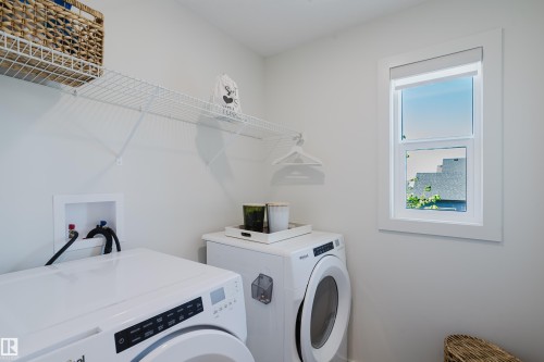 Laundry area with white wire shelving, a window, and appliance hookups - 7017 52 Avenue, Beaumont, AB 