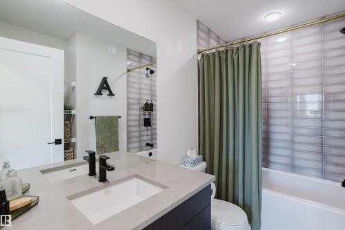 Vanity with integrated sink, matte black faucets, and light-toned countertop - 7017 52 Avenue, Beaumont, AB 
