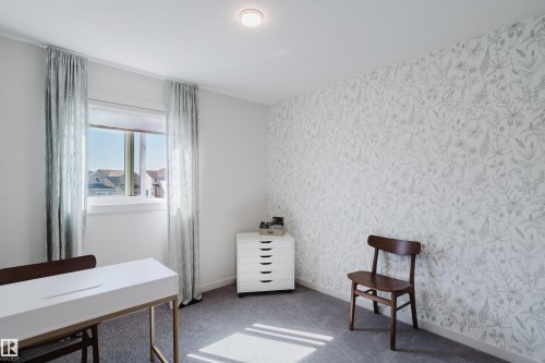 Recessed ceiling light, single window, patterned accent wall, light-colored walls, and carpet flooring - 7017 52 Avenue, Beaumont, AB 