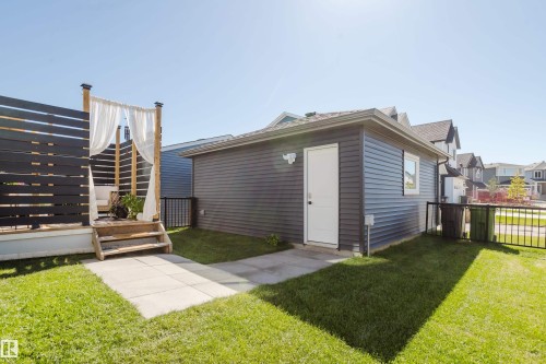 Detached garage with horizontal siding, a side entry door, and a single window - 7017 52 Avenue, Beaumont, AB 