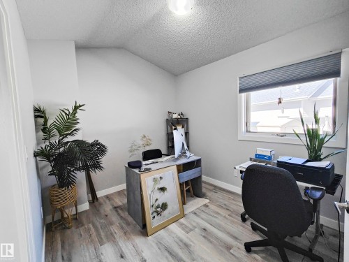 Light-toned wood-finish flooring, a window with horizontal blinds, and a built-in ceiling light fixture - 215 Peter Close Nw, Edmonton, AB 