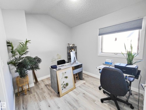 Light wood-finish flooring, neutral wall paint, and a large window with privacy blinds - 215 Peter Close Nw, Edmonton, AB 