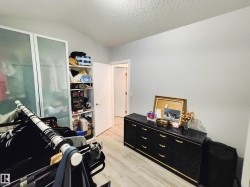 Light wood-finish flooring with white walls and a vaulted ceiling - 