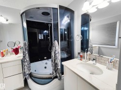 Curved glass shower enclosure with integrated tub, white vanity with an undermount sink, countertop with a polished finish, and a subway tile backsplash - 